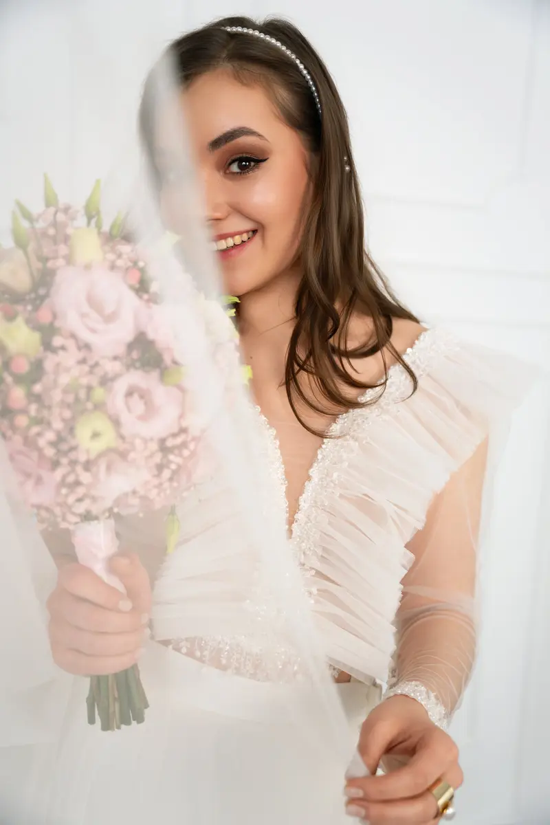 Braut mit Tüllärmeln und Rosen